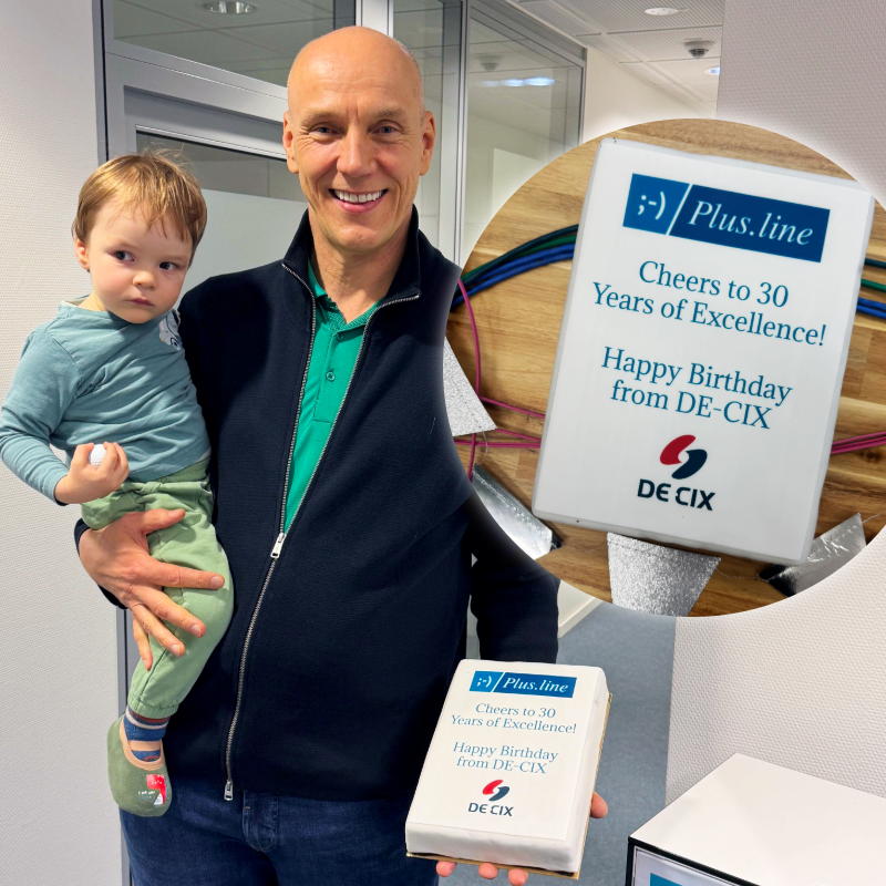 Plus.line AG Vorstand Richard Gresek hält ein Geschenk der DE-CIX (Eine Torte) in die Kamera
